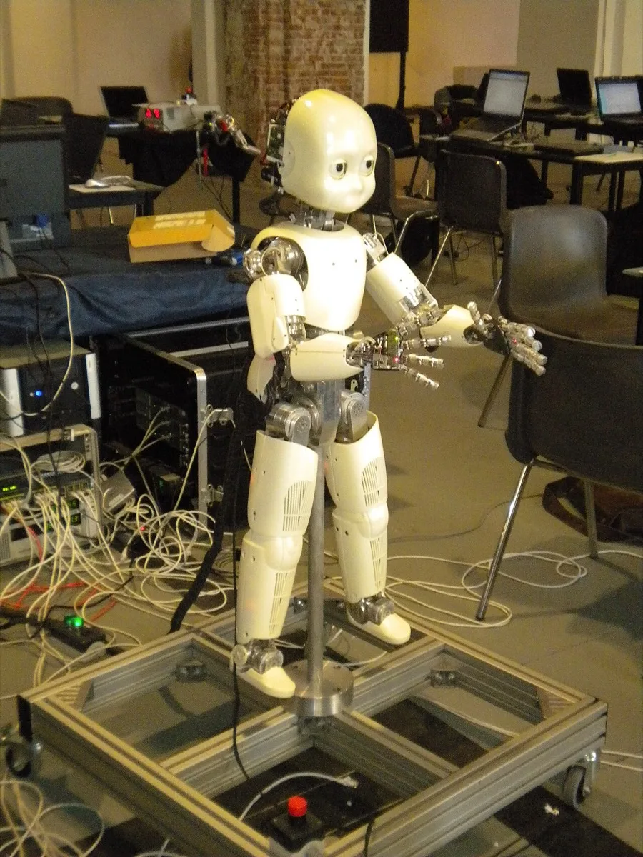 Full-body view of an iCub humanoid robot mounted on a support frame