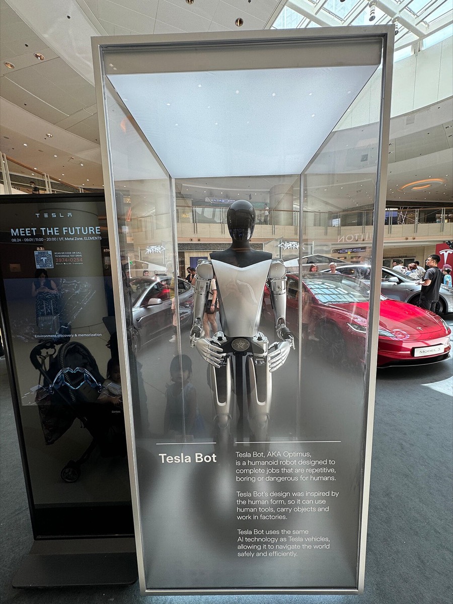 Tesla Optimus displayed inside a glass case at a Tesla showroom in Hong Kong