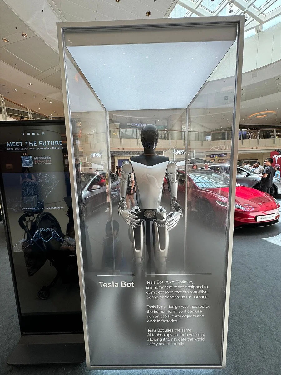 Tesla Optimus displayed inside a glass case at a Tesla showroom in Hong Kong