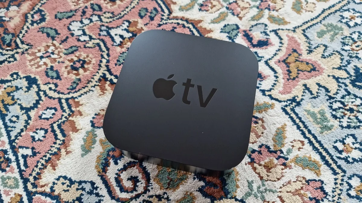 Apple TV 4K set-top box with the Apple TV logo on top, shown next to its Siri Remote