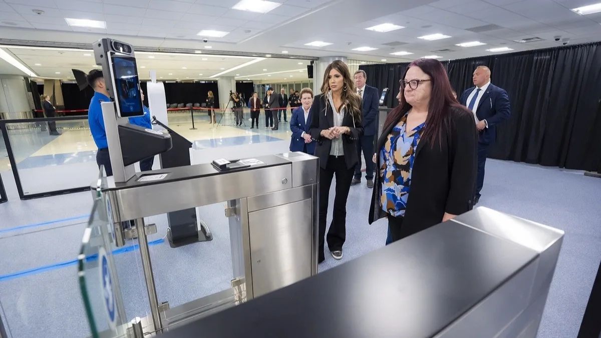 Traveler scanning an ID at a TSA identity verification kiosk in an airport security checkpoint