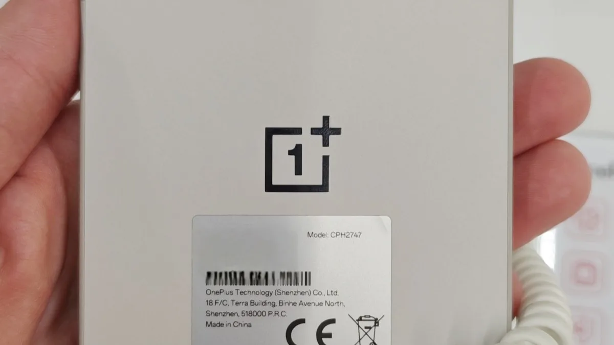 Back panel of a OnePlus 15 handset showing its logo and regulatory label