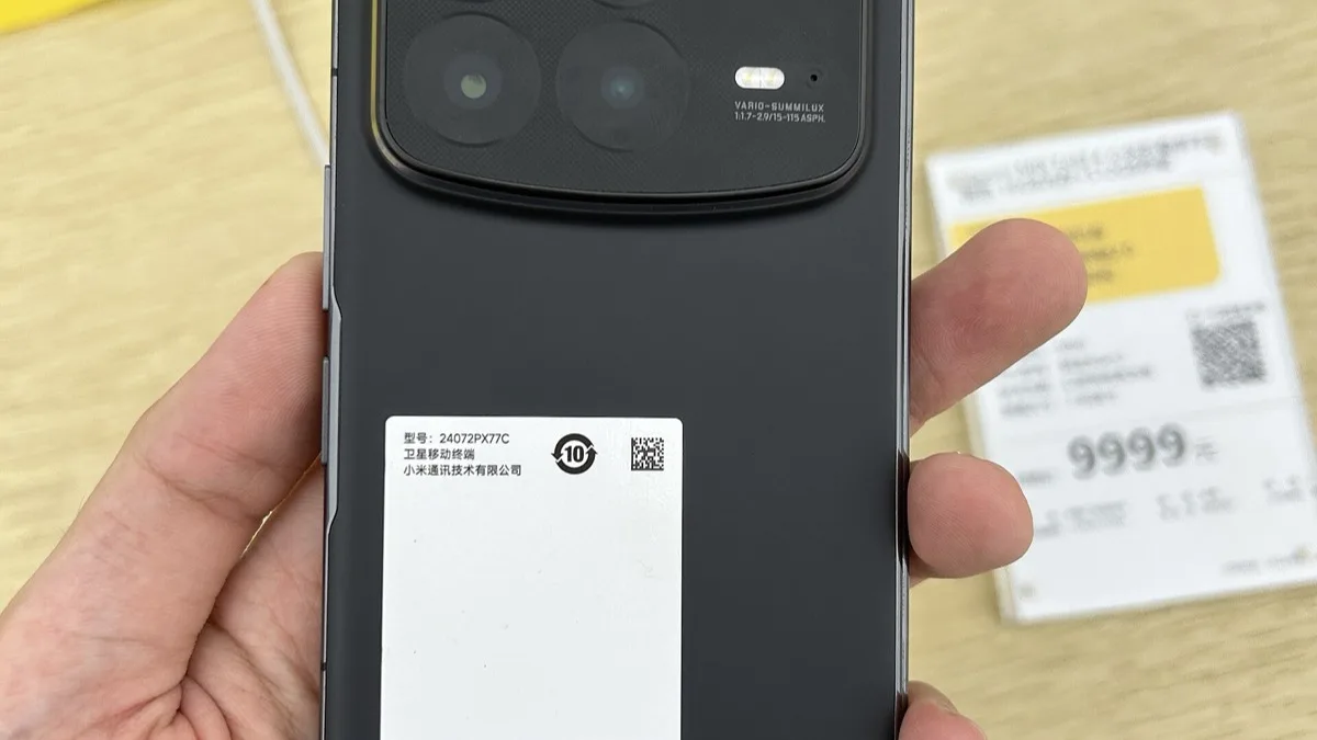 A hand holding a Xiaomi foldable phone showing its camera module and a retail price tag
