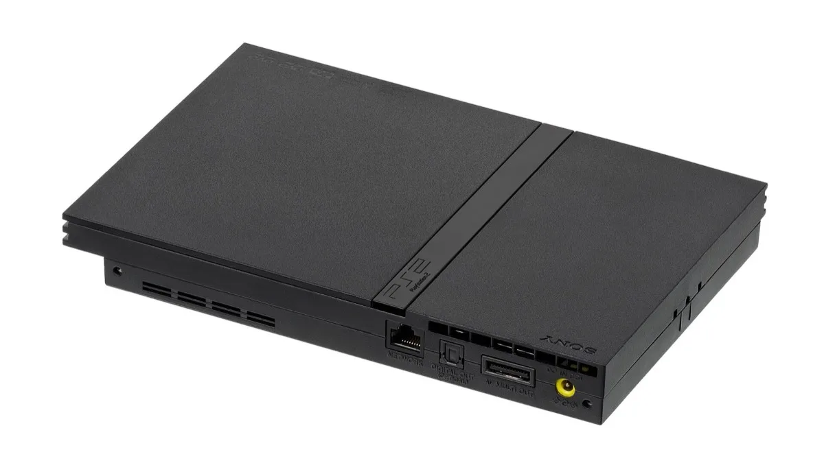 A slim black Sony PlayStation 2 console photographed at an angle, showing its rear network, optical audio and AV ports