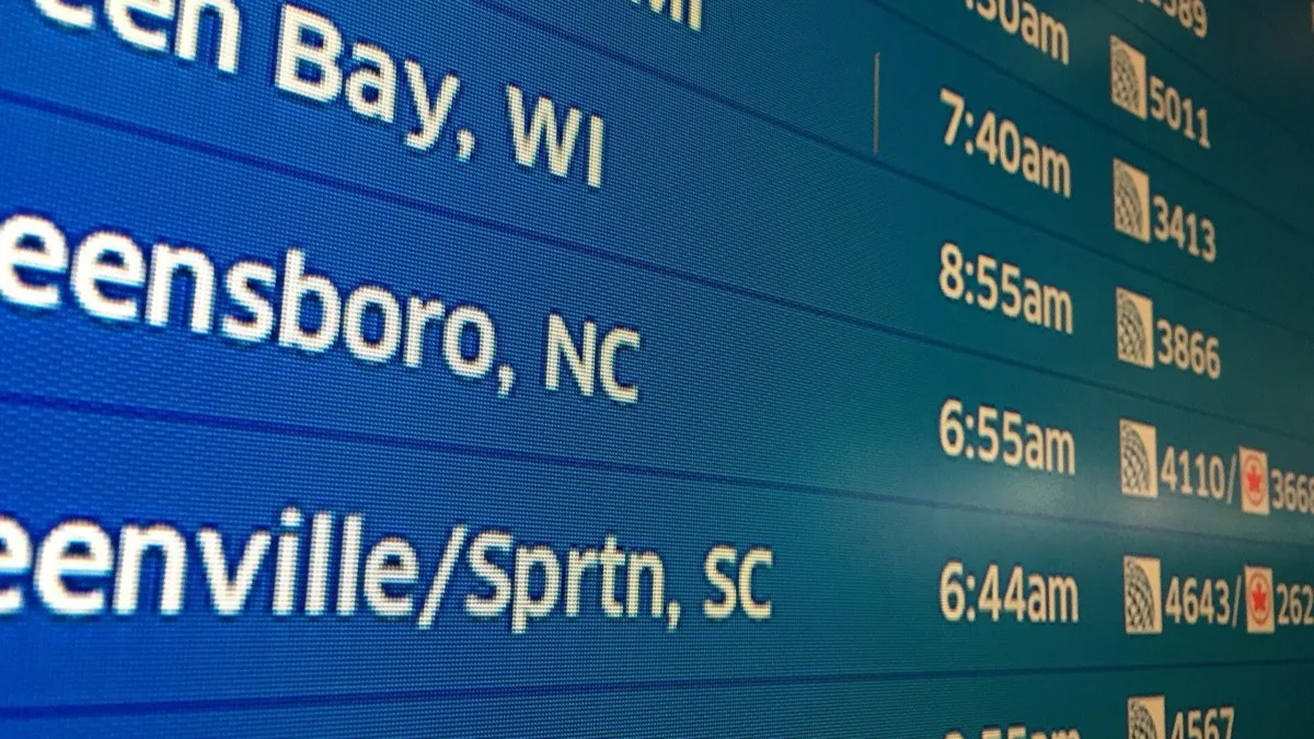 Close-up of an airport departure board showing flight times and destinations