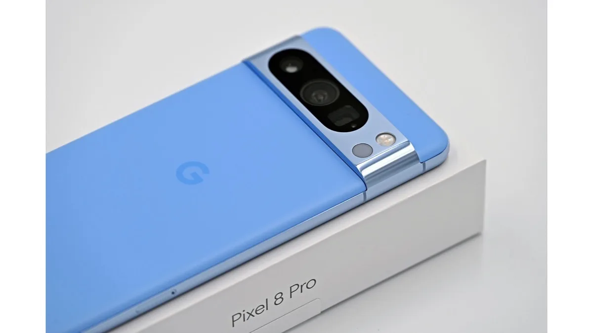 A blue Google Pixel phone with its triple rear camera resting on its retail box