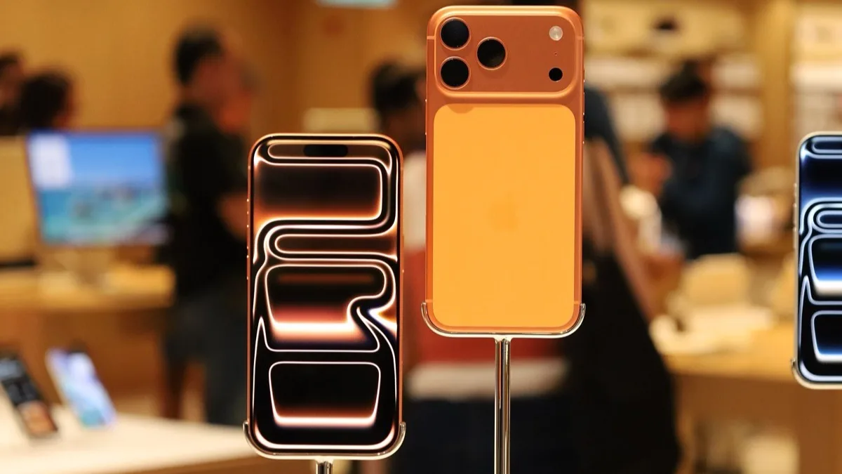 iPhones on display stands inside an Apple Store, showing their rear camera arrays and screens