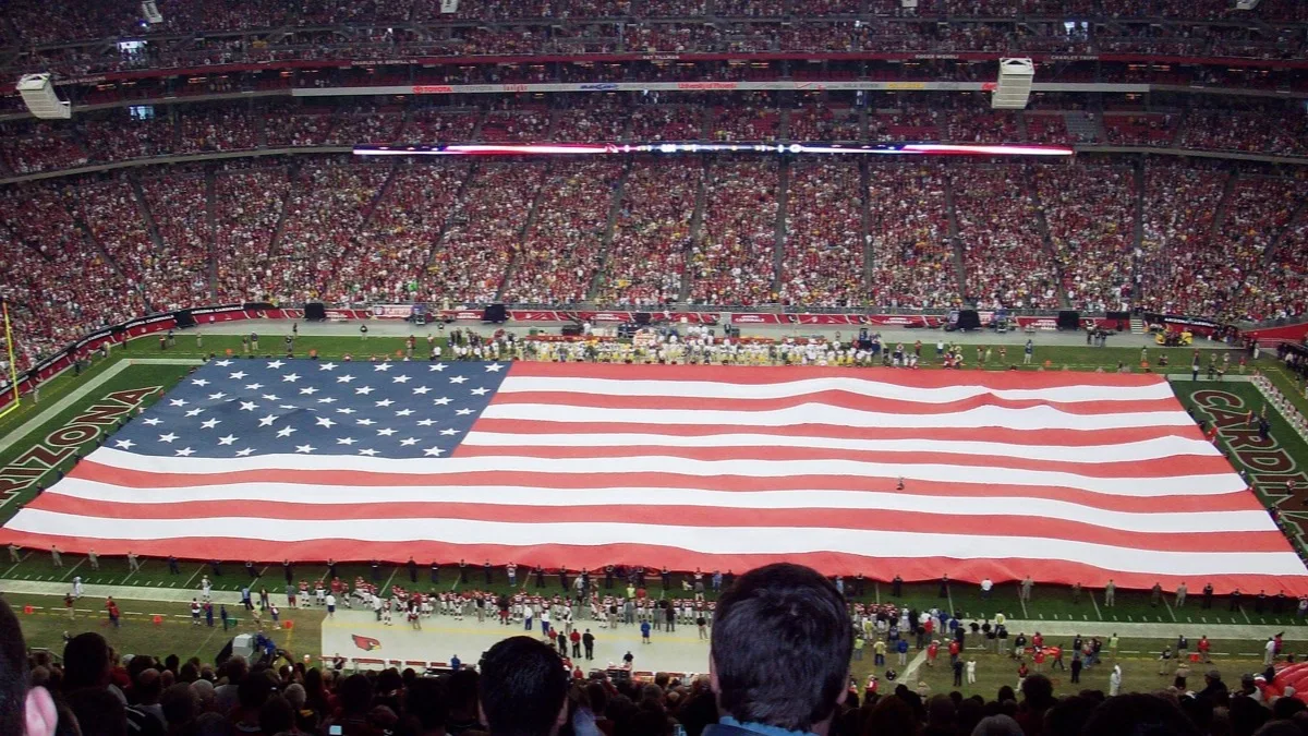 A packed NFL stadium during pre-game ceremonies, illustrating the league licence behind Madden NFL 27 Arcade Edition
