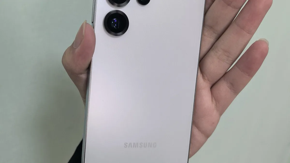 Rear view of a Samsung Galaxy phone's camera module and glossy back panel, held in a hand