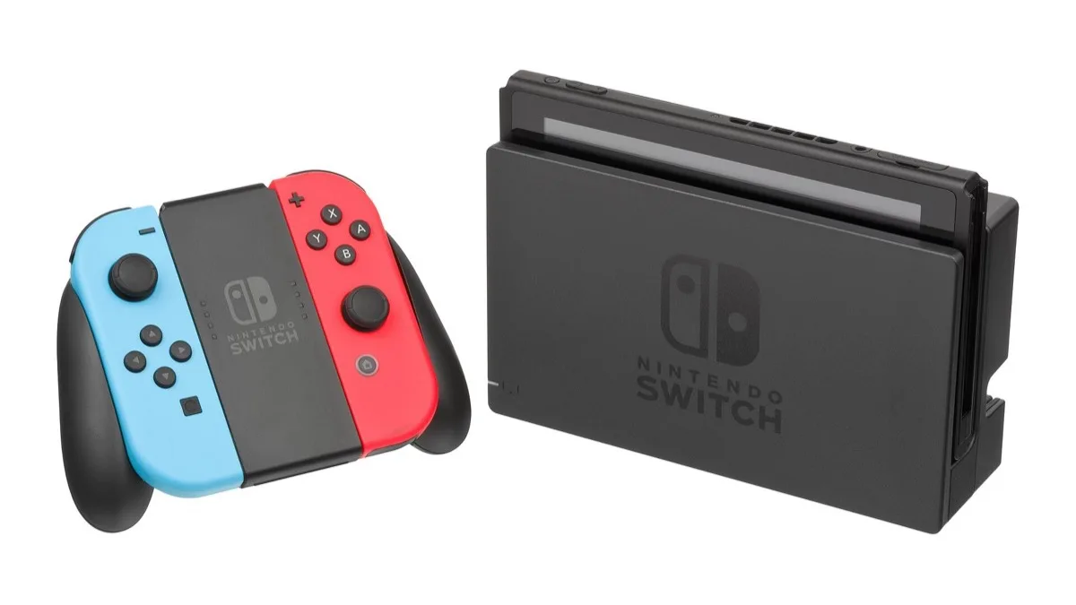 A docked Nintendo Switch console beside a Joy-Con grip holding neon blue and neon red Joy-Con controllers