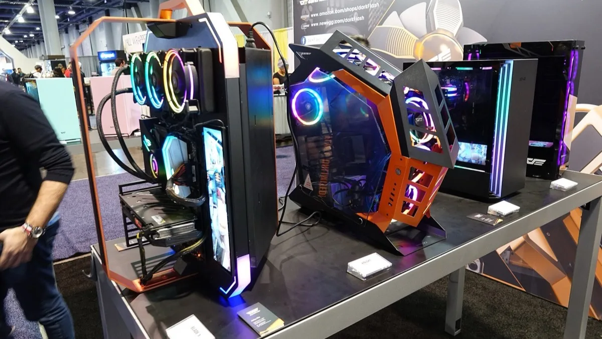 Several RGB-lit gaming PC tower cases with glass side panels lined up on a display table