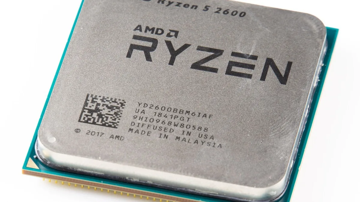 An AMD Ryzen 5 desktop processor resting on a white surface, showing the heat spreader and AM4 pin grid