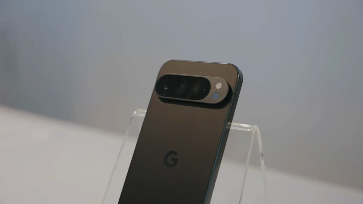 Back of a Google Pixel 9 Pro in obsidian on a clear acrylic stand, showing its camera bar