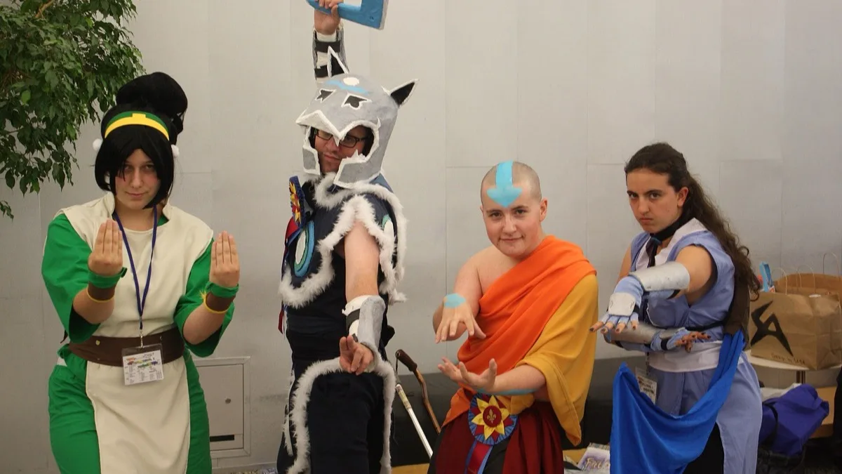 Four fans in Avatar: The Last Airbender costumes pose together at an anime convention