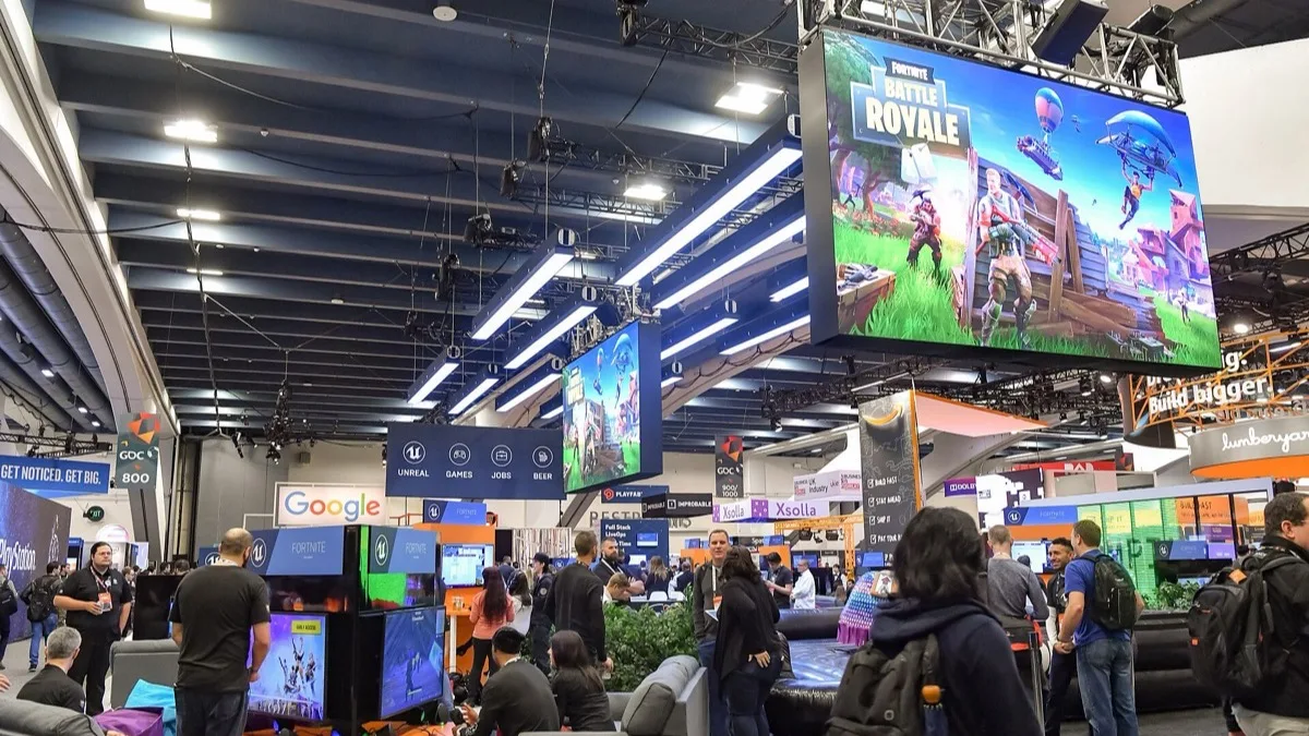 Fortnite Battle Royale artwork on a large screen above Epic Games' Unreal booth at the Game Developers Conference in 2018