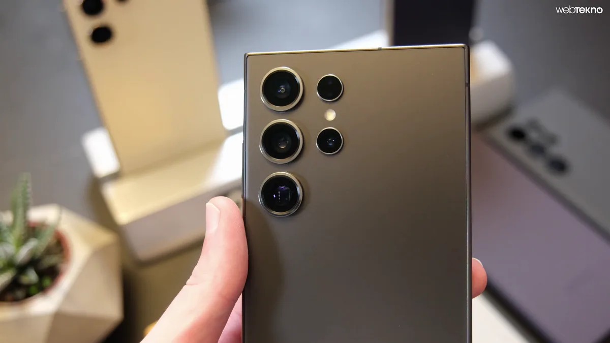 Rear of a titanium Samsung Galaxy S24 Ultra held in a hand, showing its five-ring camera array