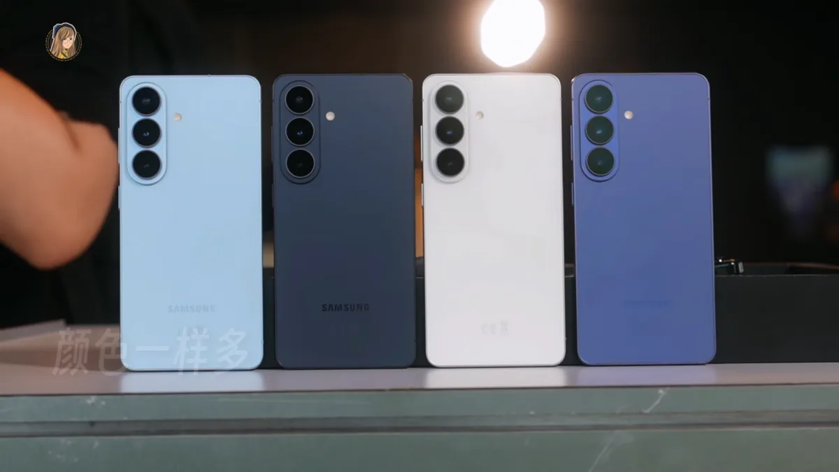 Four Galaxy S26 series phones in light blue, navy, white and violet standing upright on a table, rear cameras facing out