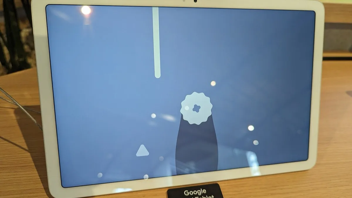 Google Pixel Tablet propped on a wooden retail display table with its store label visible
