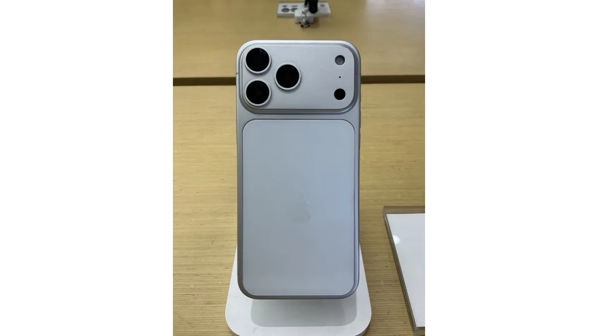 An iPhone Pro Max on a white display stand in an Apple Store, shown from the back