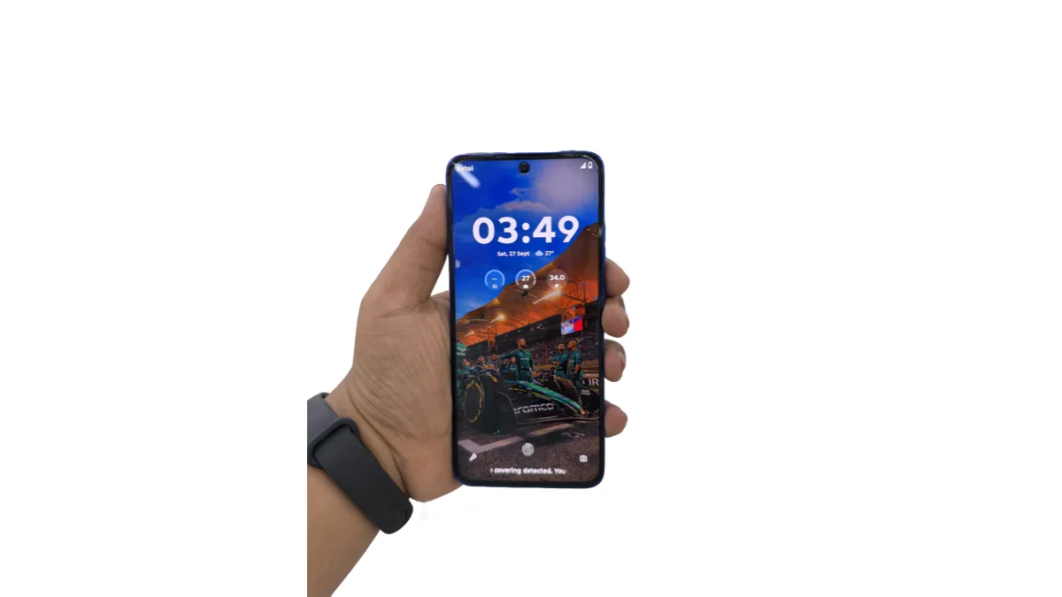 A Motorola Edge-series phone held in one hand, showing its lock screen clock and weather widgets
