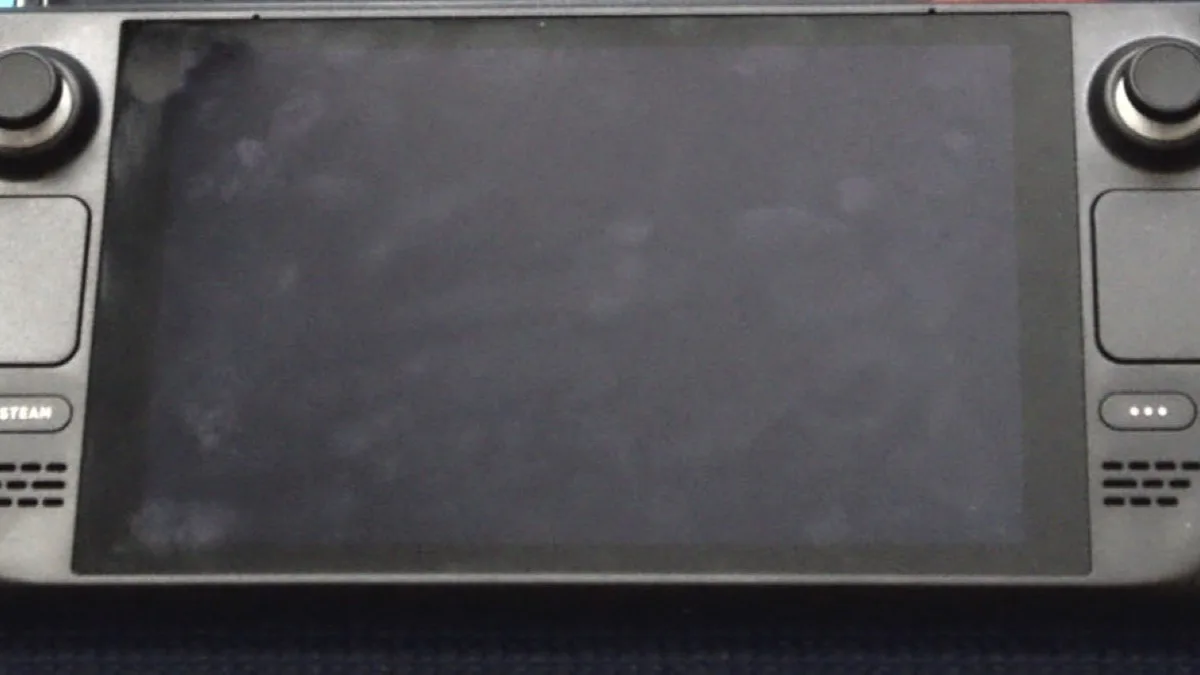A Steam Deck handheld gaming PC with its screen switched off, showing the Steam button and both thumbsticks