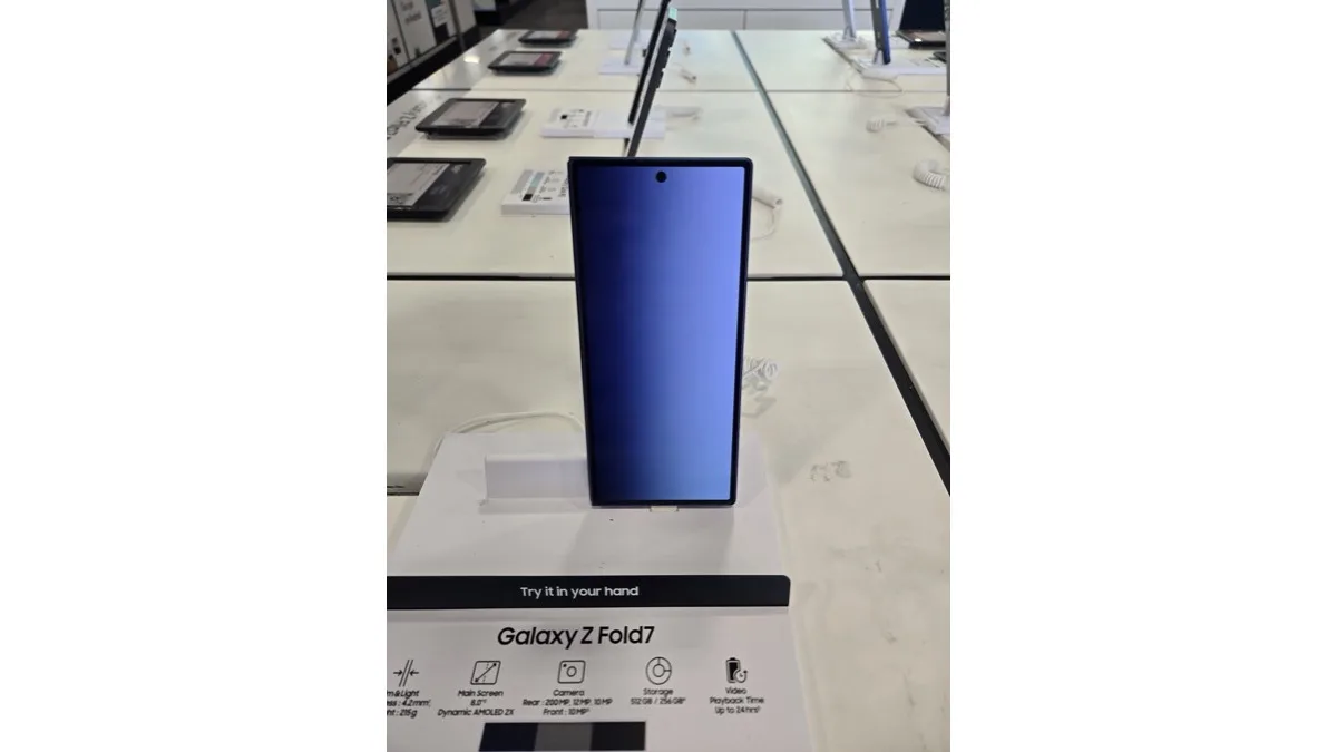 A Galaxy Z Fold7 standing upright on a store display stand next to its spec card