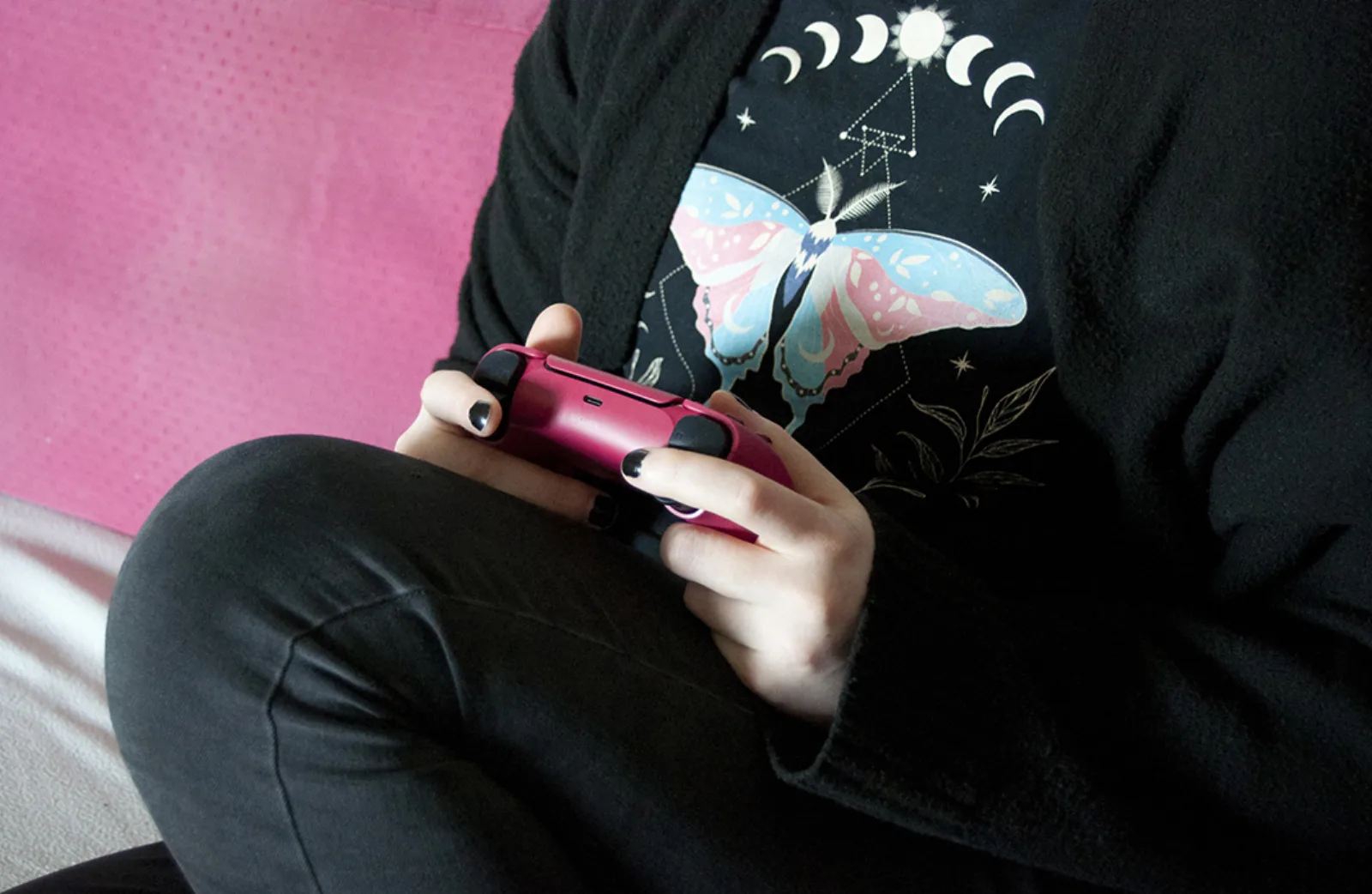 Person holding a DualSense controller, the pairing pose before connecting it to an Android phone