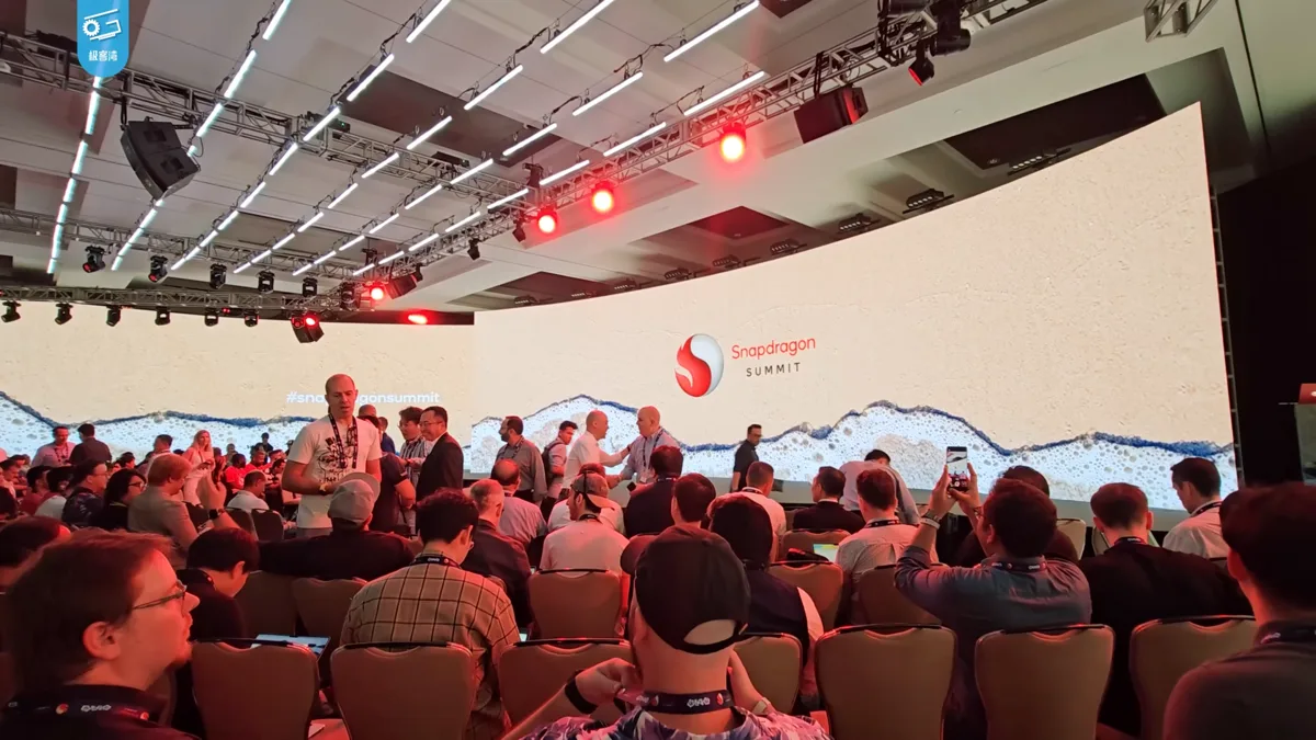 Attendees seated in front of a large Snapdragon Summit stage screen at a Qualcomm event