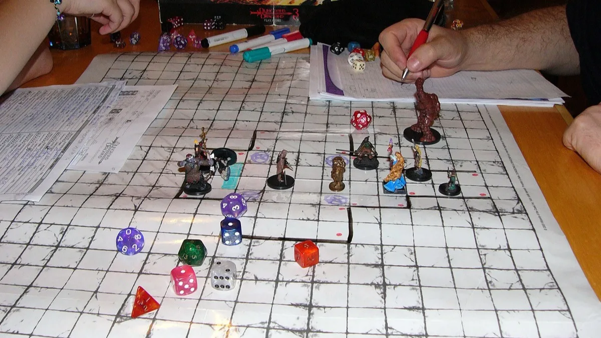 A tabletop Dungeons & Dragons session in progress, with miniatures and polyhedral dice spread across a gridded battle map
