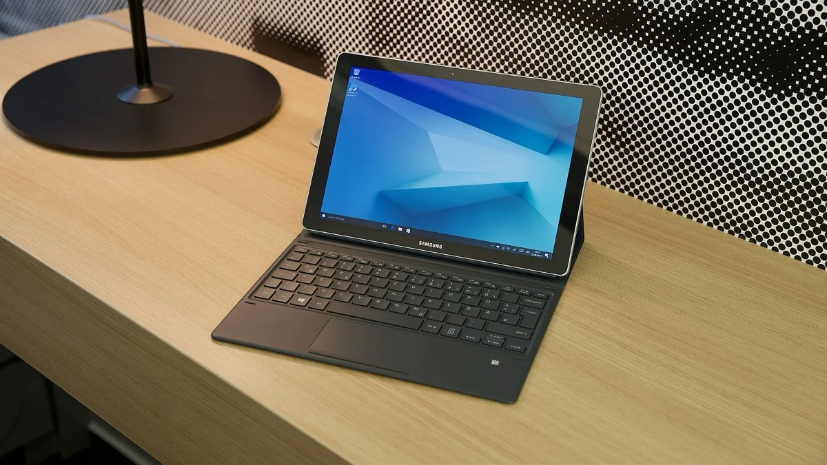 A Samsung Galaxy Book laptop with its keyboard attached, sitting open on a wooden desk
