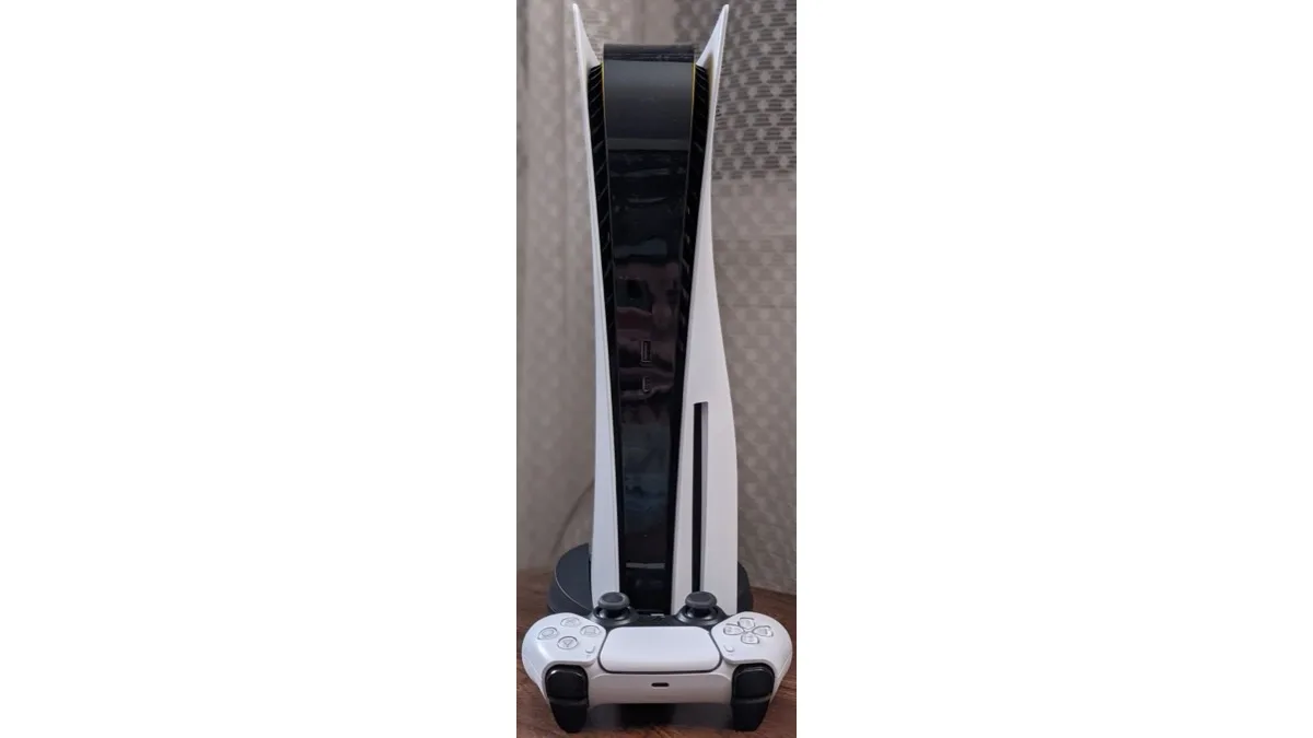 A white PlayStation 5 console standing upright with a white DualSense controller resting in front of it
