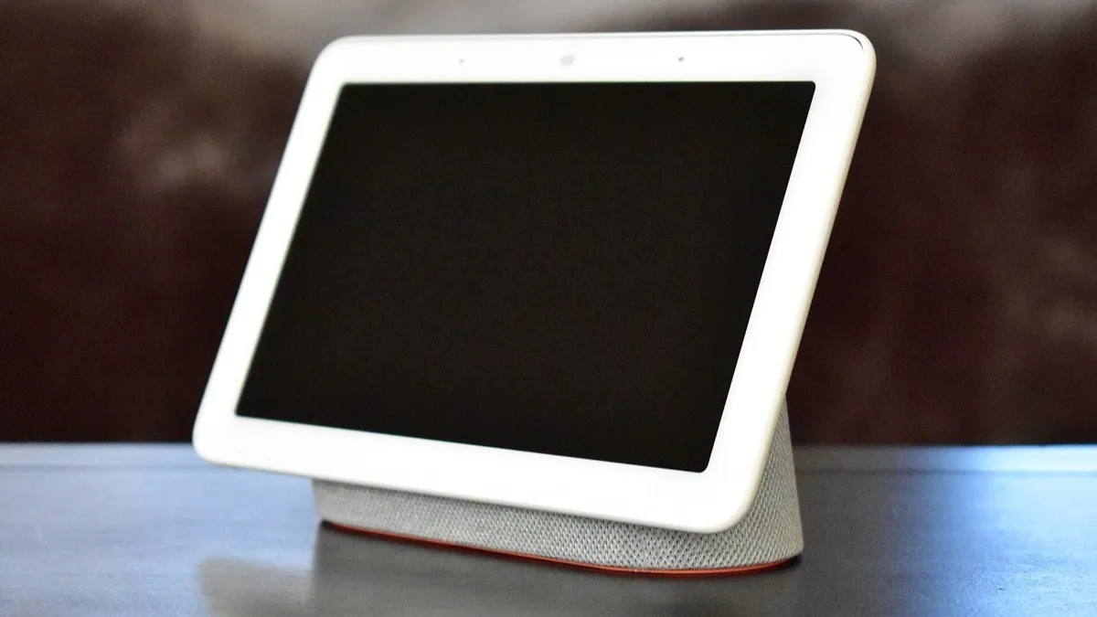 A fabric-based smart home hub with a blank touchscreen sitting on a table