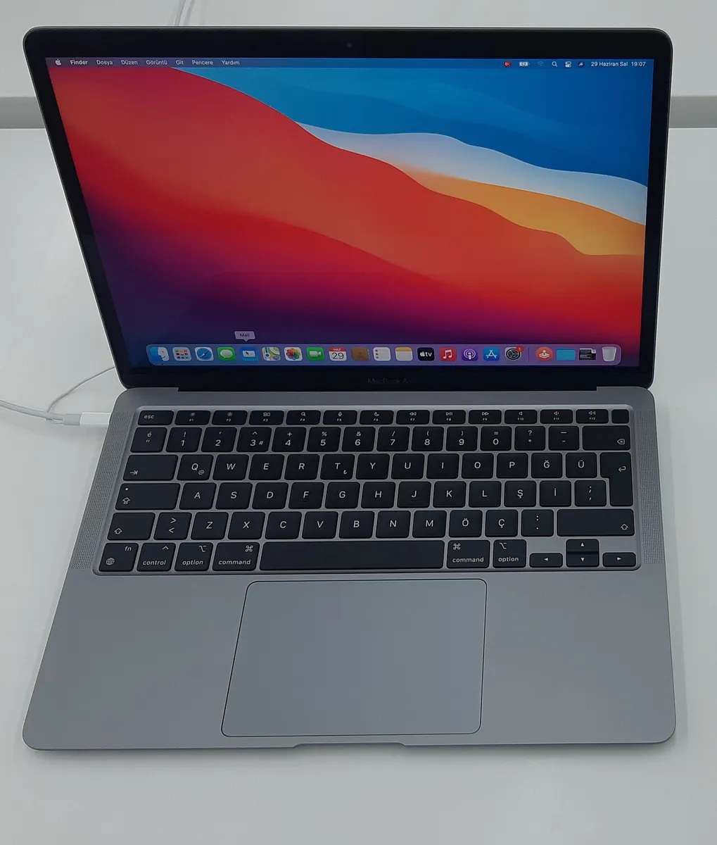 MacBook Air with an Apple M1 chip open on a desk, showing the macOS desktop