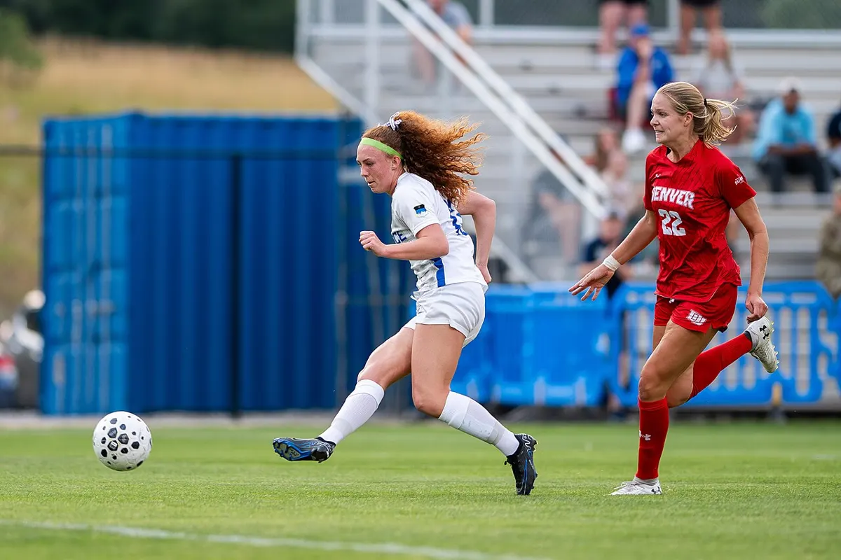 Soccer player shooting the ball during a college match