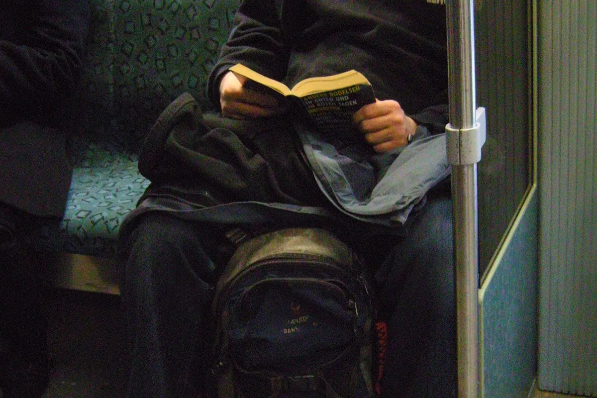 A commuter reading a paperback novel
