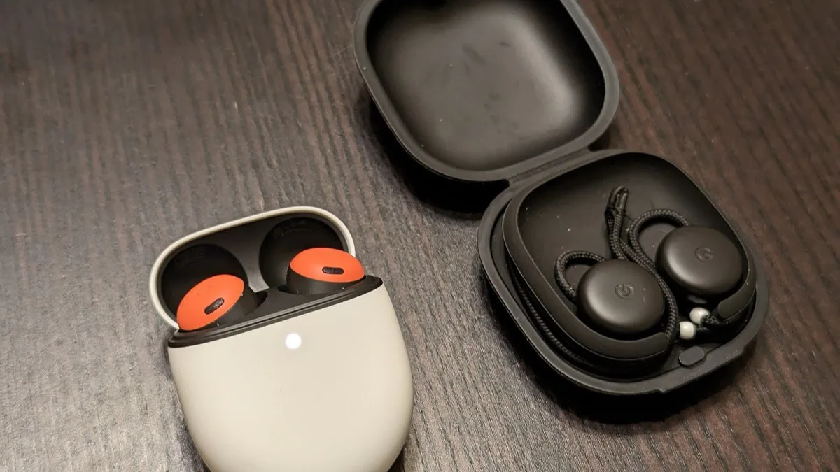 Original Google Pixel Buds Pro in an open white case beside the 2017 Pixel Buds in their black fabric case