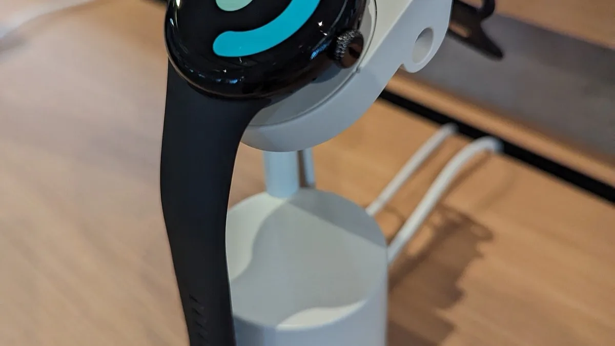 Google Pixel Watch 2 with a black band on a white display stand in a store